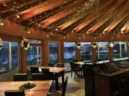 dekorierter Innenbereich mit Tischen und Sesseln und Bar
